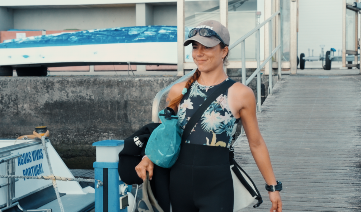 Diver with dive gear and accessories heading to the boat.