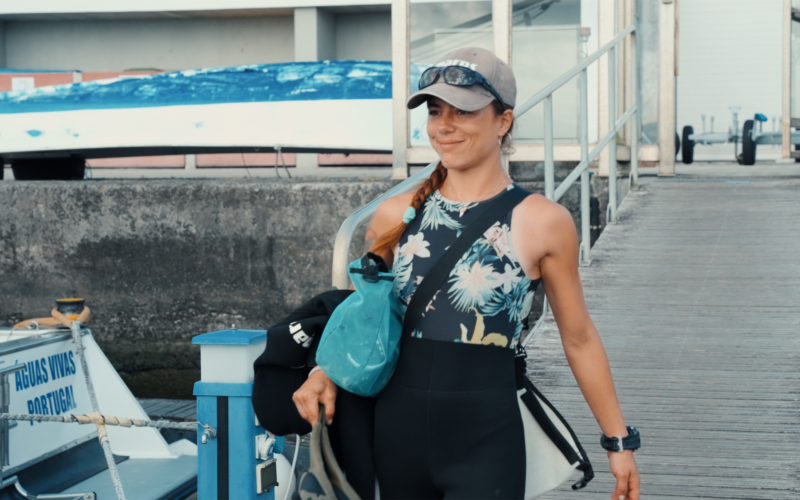 Diver with dive gear and accessories heading to the boat.