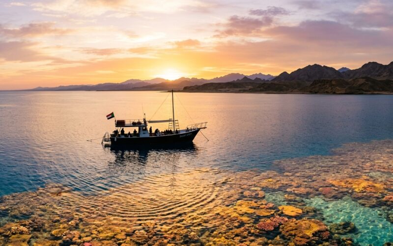 Remote Red Sea dive boat near reef at sunrise in Sudan